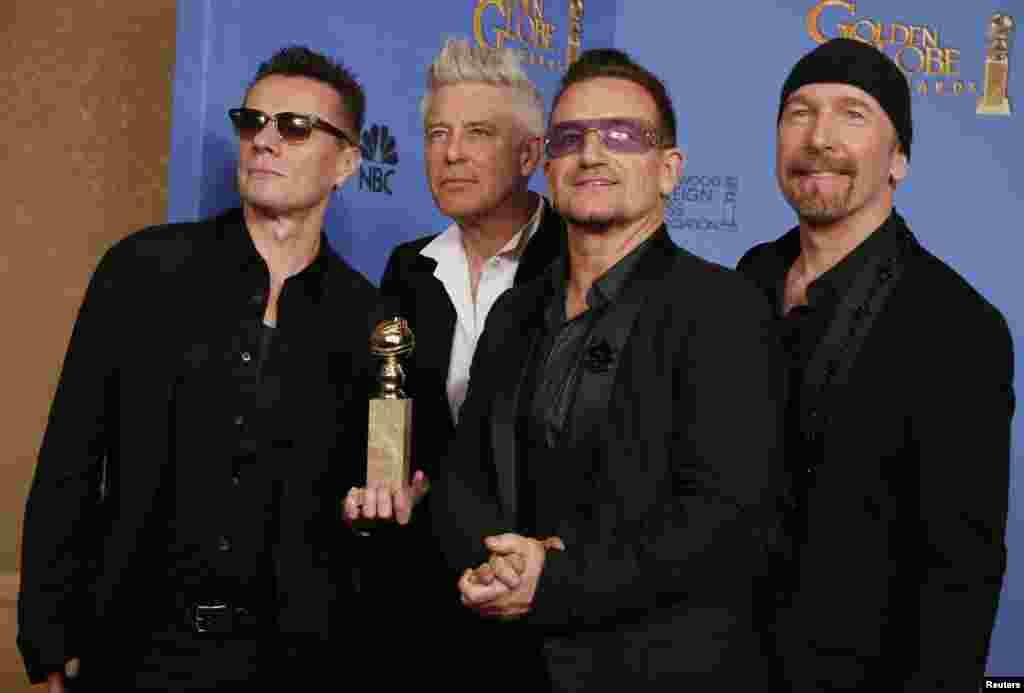 Adam Clayton, Bono, Larry Mullen, Jr. dan The Edge dari band U2 berpose di belakang panggung dengan penghargaan untuk Lagu Tema Terbaik " Ordinary Love" dari film "Mandela: Long Walk to Freedom" 12 Januari 2014.