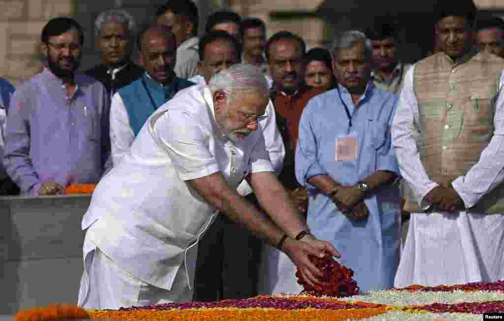 Indian Prime Minister-designate Narendra Modi scatters rose petals at the Mahatma Gandhi memorial at Rajghat ahead of his swearing-in ceremony in New Delhi, India, May 26, 2014.