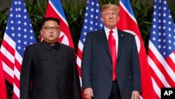 ARSIP – Presiden AS, Donald Trump, kanan, bertemu dengan pemimpin Korut, Kim Jong Un di Sentosa Island, di Singapura, 12 Juni 2018 (foto: AP Photo/Evan Vucci, Arsip)