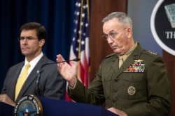 FILE - Joint Chiefs Chairman Gen. Joseph Dunford, with Secretary of Defense Mark Esper, speaks to reporters during a briefing at the Pentagon, Aug. 28, 2019.