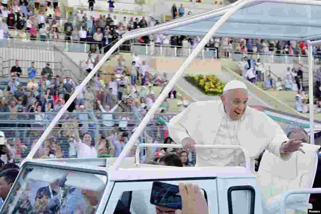 Pope Francis waves to the faithful as he leaves after a mass at Amman International Stadium, May 24, 2014.