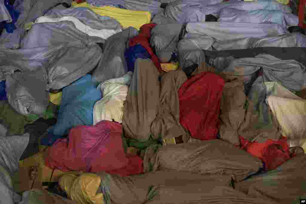 Migrants and refugees rest on the deck of a ship after being rescued, in the Mediterranean Sea off the coast of Libya.
