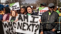 Women protest outside the Krugersdorp, South Africa, Magistrates Court, Aug. 1, 2022. More than 80 men suspected of the gang rapes of eight women and armed robbery of a video production crew appeared in court Monday.