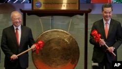 Hong Kong Exchanges and Clearing Ltd. Chairman Chow Chung-kong, left, and Hong Kong Chief Executive Leung Chun-ying pose before beating a gong during the launch ceremony of the Shanghai-Hong Kong Stock Connect in Hong Kong Monday, Nov. 17, 2014.