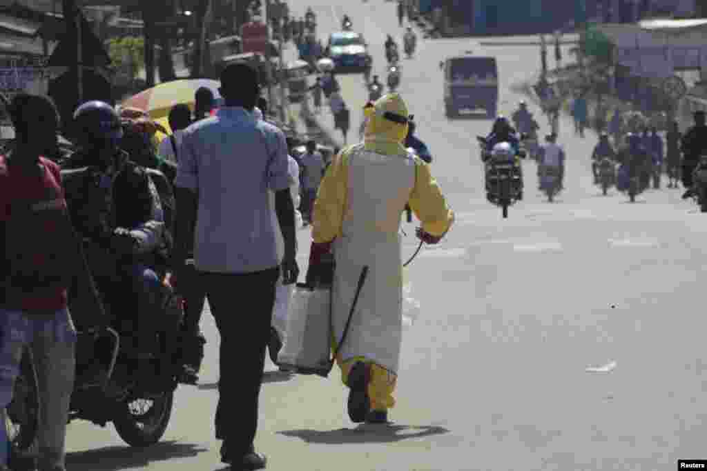 A health worker with disinfectant spray walks down a street outside the government hospital in Kenema, Sierra Leone, July 10, 2014. 