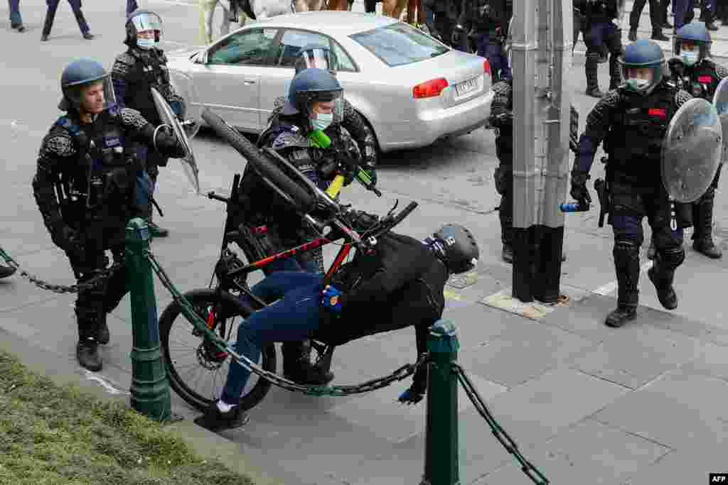 A demonstrator is handled as police officers disperse a protest against Covid-19 regulations in Melbourne, Australia.