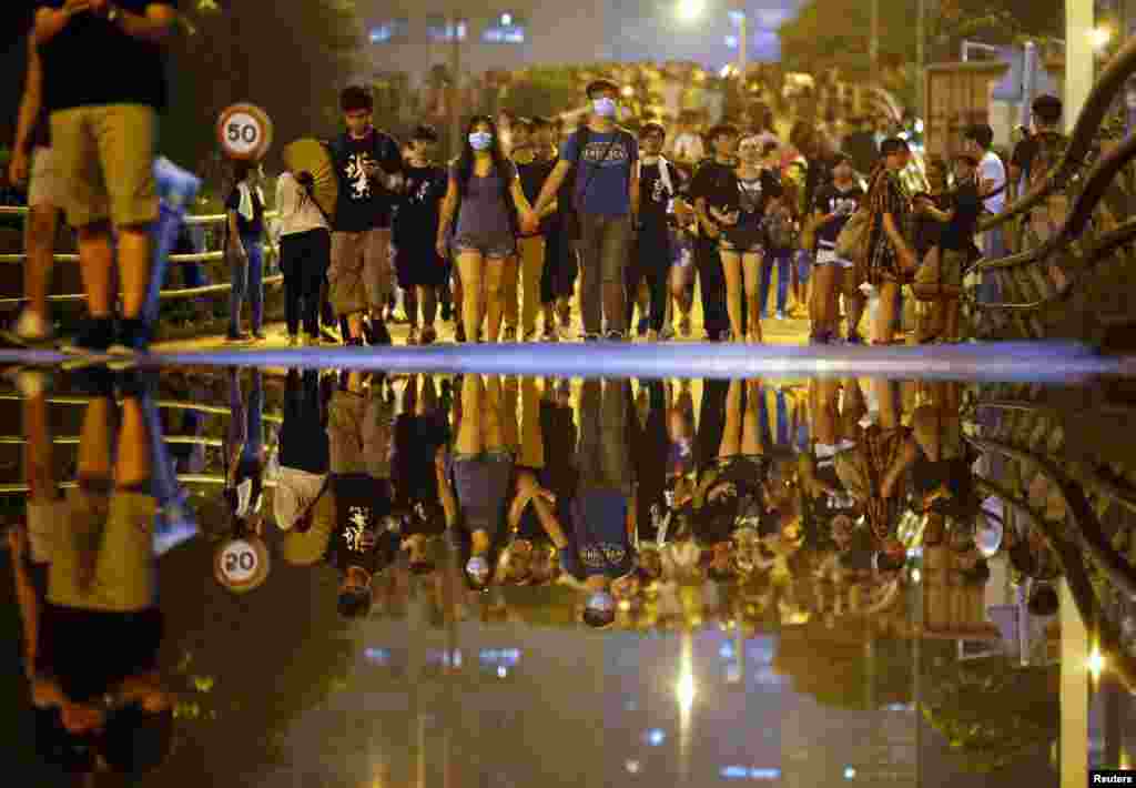 Protesters walk along a street as they block an area near the government headquarters building, in Hong Kong, Sept. 30, 2014.