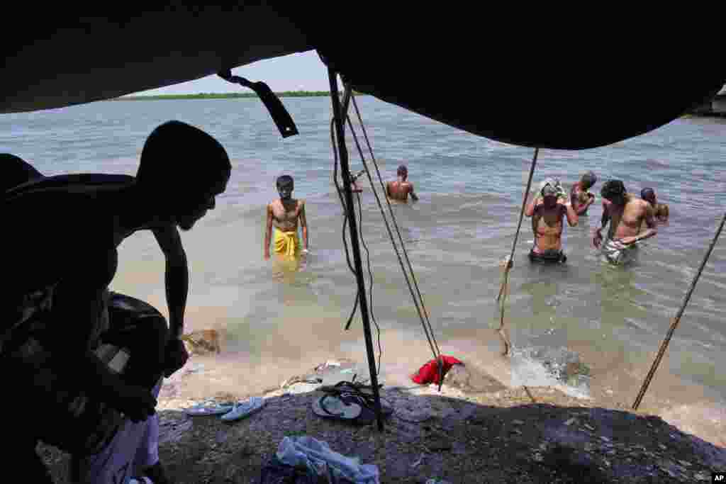 Bangladeshi men wash themselves in the sea near a temporary shelter in Langsa, Aceh province, Indonesia, May 19, 2015. Indonesia's foreign minister said that her country has "given more than it should" to help hundreds of Rohingya and Bangladeshi migrants stranded on boats by human traffickers.