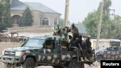 FILE - Nigerian military secure the area where a man was killed by suspected militants during an attack around Polo area of Maiduguri, Nigeria, Feb. 16, 2019. 
