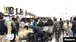 Maafisa wa usalama Somalia waskikagua gari iliyoteketezwa kwa mlipuko wa bomu Mogadishu, Somalia, Julia 13, 2020. 