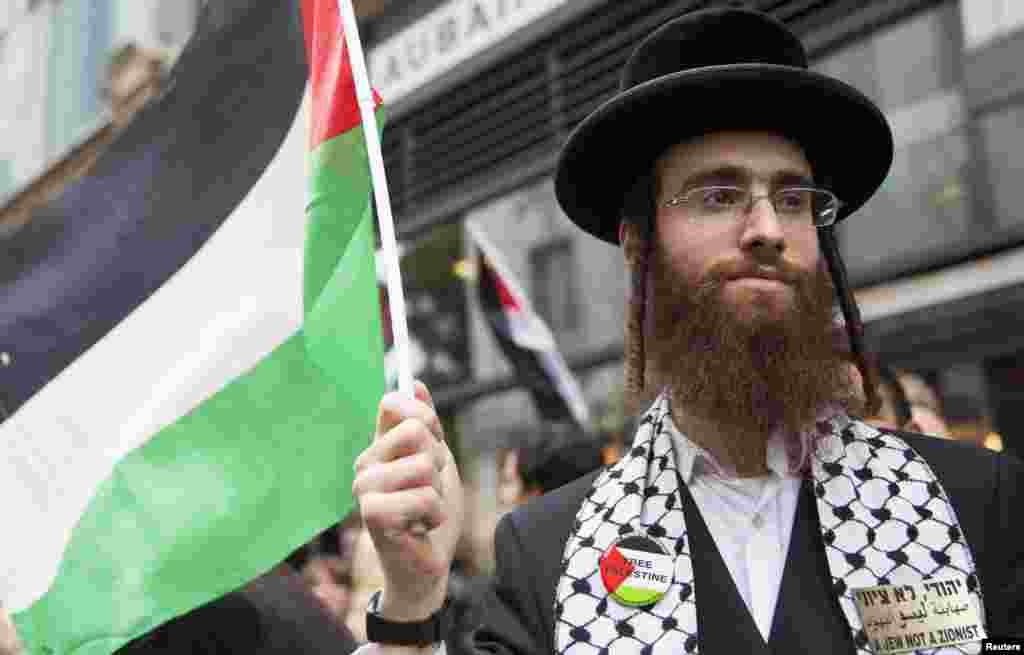 Seorang Yahudi Orthodox memegang bendera Palestina dalam protes menentang serangan udara Israel di Gaza, London, 11 Juli 2014.