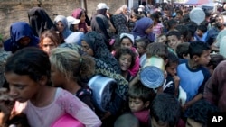 Palestinyen fe lake pandan distribisyon manje nan Deir al-Balah nan Gaza, 17 Oktob, 2024.