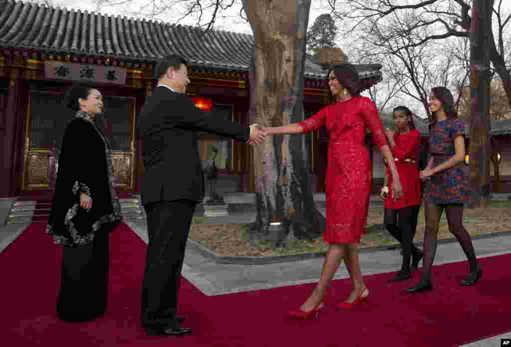 U.S. first lady Michelle Obama, followed by her daughters Malia and Sasha, is greeted by Chinese President Xi Jinping and his wife Peng Liyuan at the Diaoyutai State guest house in Beijing, March 21, 2014.