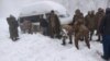 Seorang tentara membersihkan salju di bawah kendaraan yang terdampar setelah hujan salju lebat di Murree, Pakistan 8 Januari 2022. (Foto: Inter Services Public Relations/ISPR via REUTERS)