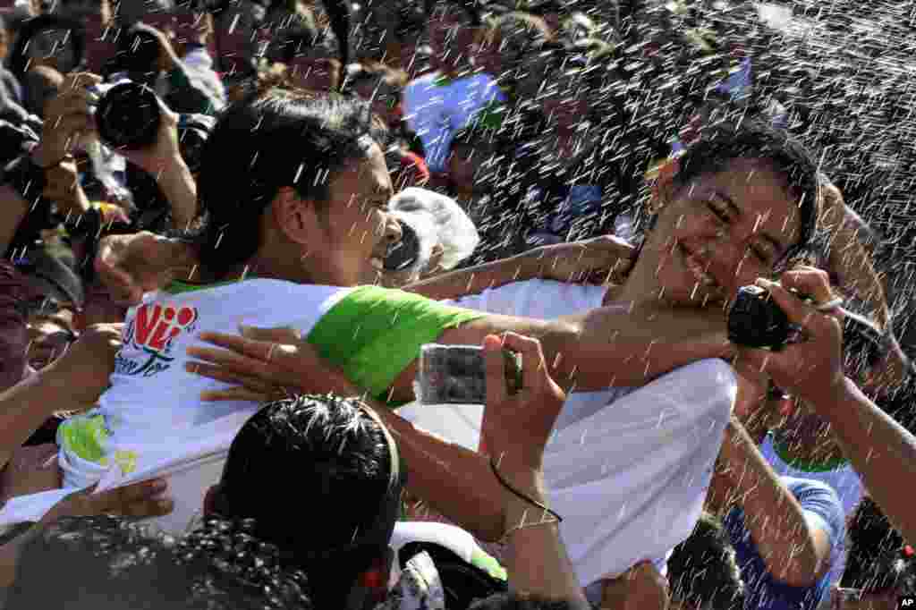 Seorang gadis Bali (kanan) berusaha menghindar dari ciuman seorang pria saat festival keagamaan "Omed Omedan" di Bali, Indonesia.