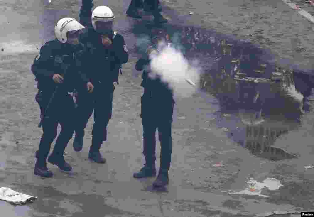Seorang polisi anti huru hara menembakkan gas air mata untuk memukul mundur para pengunjuk rasa dalam demo memperingati Hari Buruh Internasional di Istanbul, Turki.