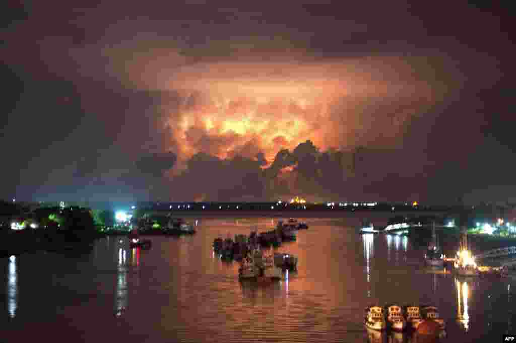 Badai tampak menerangi langit di atas sungai Yangon di Burma. Pihak berwenang Burma mulai memindahkan kamp-kamp pengungsi menjelang datangnya badai di Burma barat.