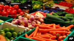 Fresh assorted vegetables in boxes at farmer's market.
