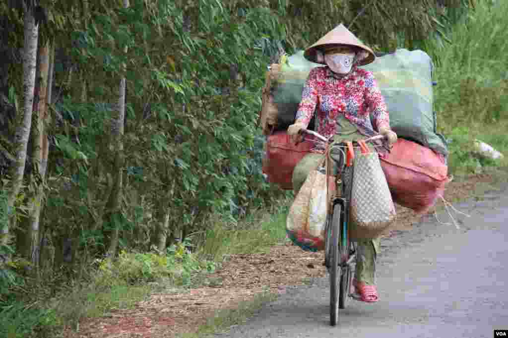 Một phụ nữ chở khá nặng trên chiếc xe đạp. 14/9/2012. (D. Schearf/VOA)